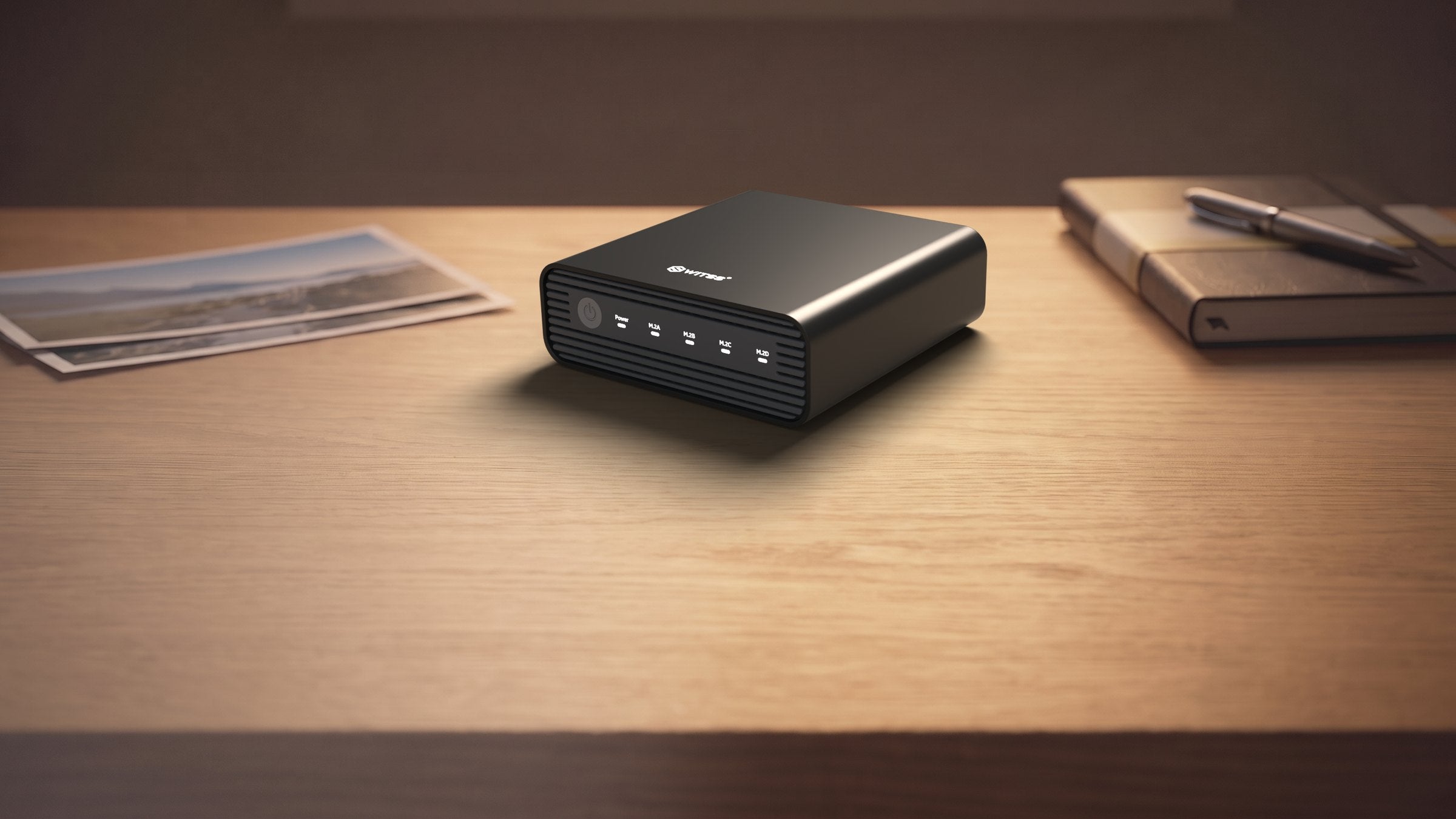Boîtier 4 baies M.2 USB-C 10 Gbit/s Switss® sur un bureau en bois, photo d’ambiance