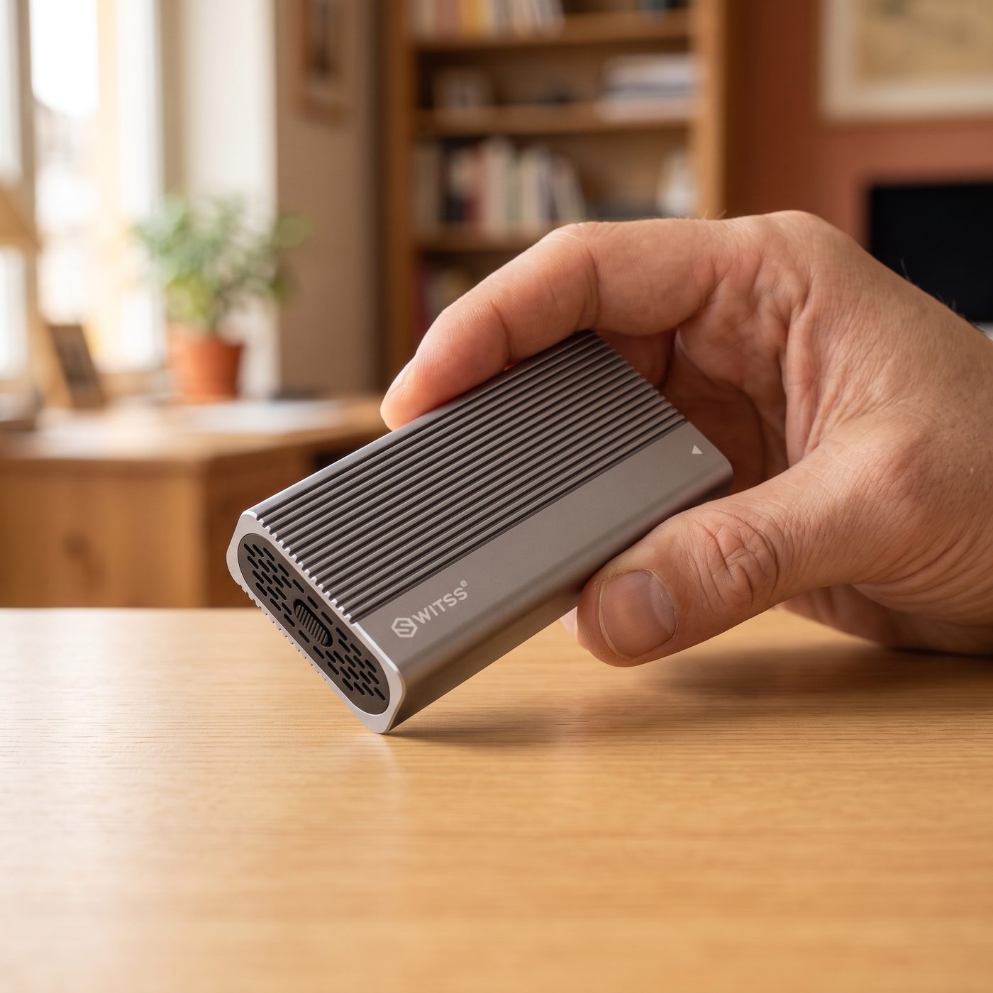 A hand holding the Switss® USB4 M.2 enclosure, showing its compact size