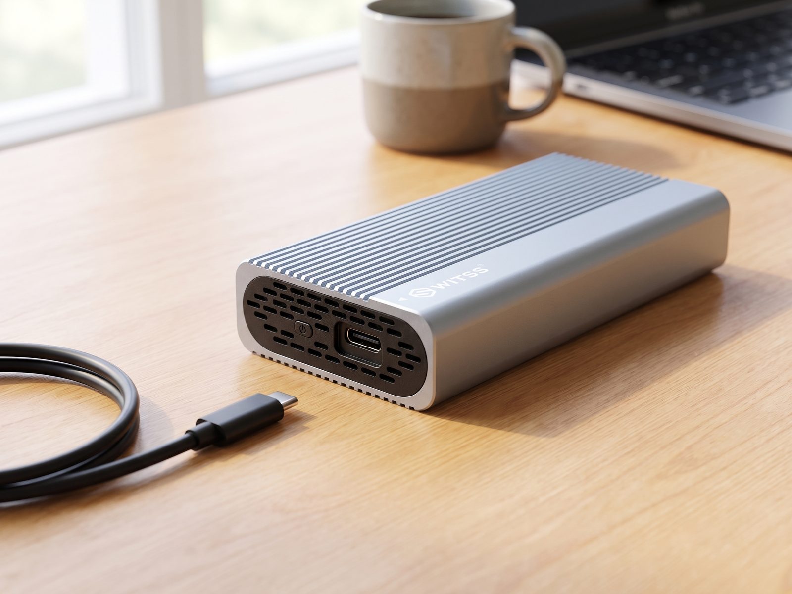 Switss® USB4 M.2 enclosure on a desk, USB-C port and heatsink fins in detail with a loose USB-C cable