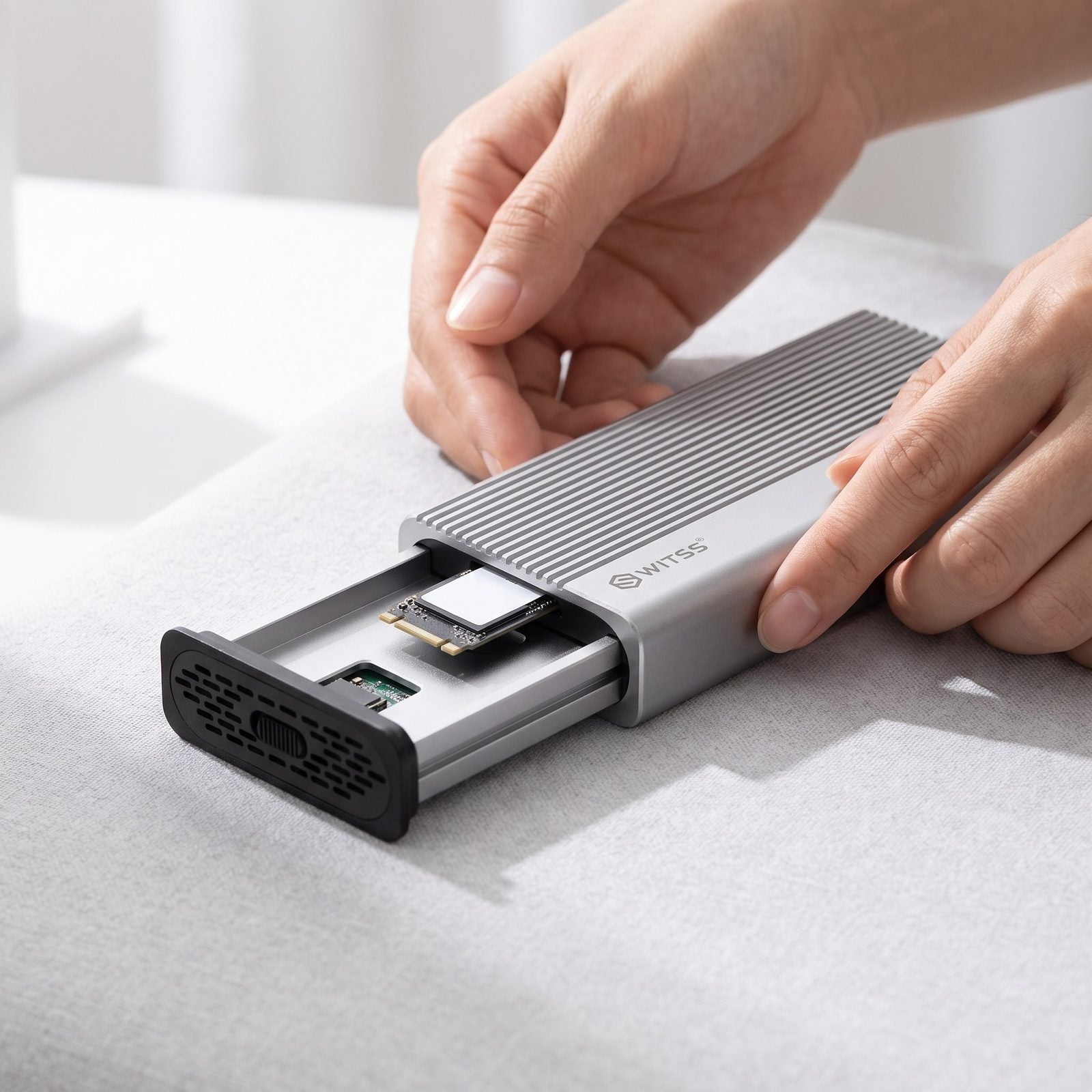 Des mains qui glissent une carte SSD M.2 dans un boîtier Switss®