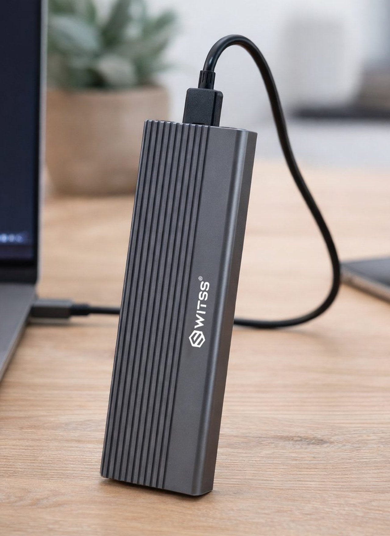 Boîtier SSD M.2 Switss® sur un bureau, relié à un ordinateur portable par un câble USB-C
