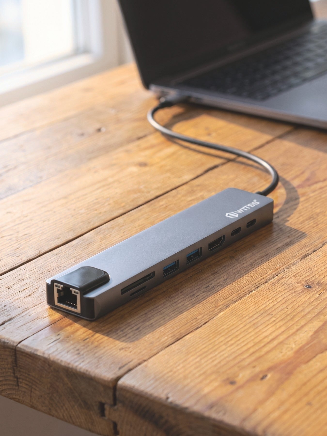 Switss® 8-in-1 hub connected to a laptop, compact on a desk