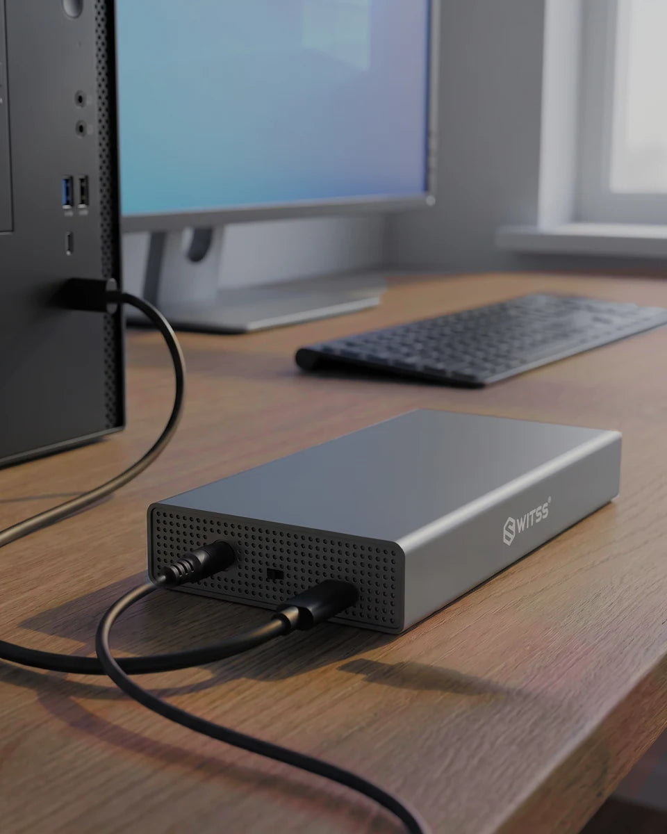 The Switss 3.5 inch enclosure on a wooden desk, with the USB cable running to a PC and the power adapter connected